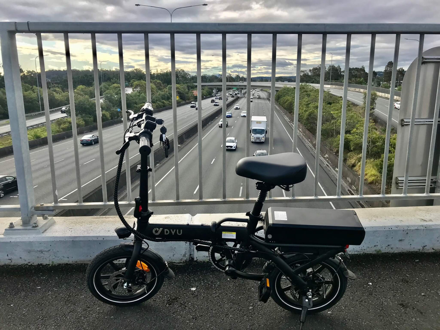 DYU A7 Electric Bike on bridge with cars in background driving on highway road