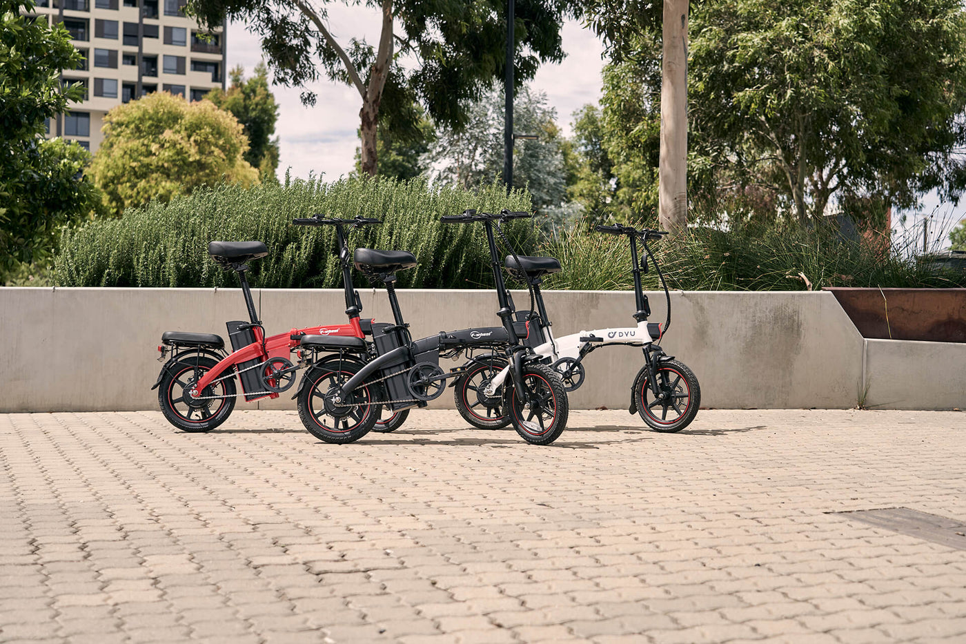 DYU A5 Electric Bike range, three different colours, red, black and white. Outdoors in the sun
