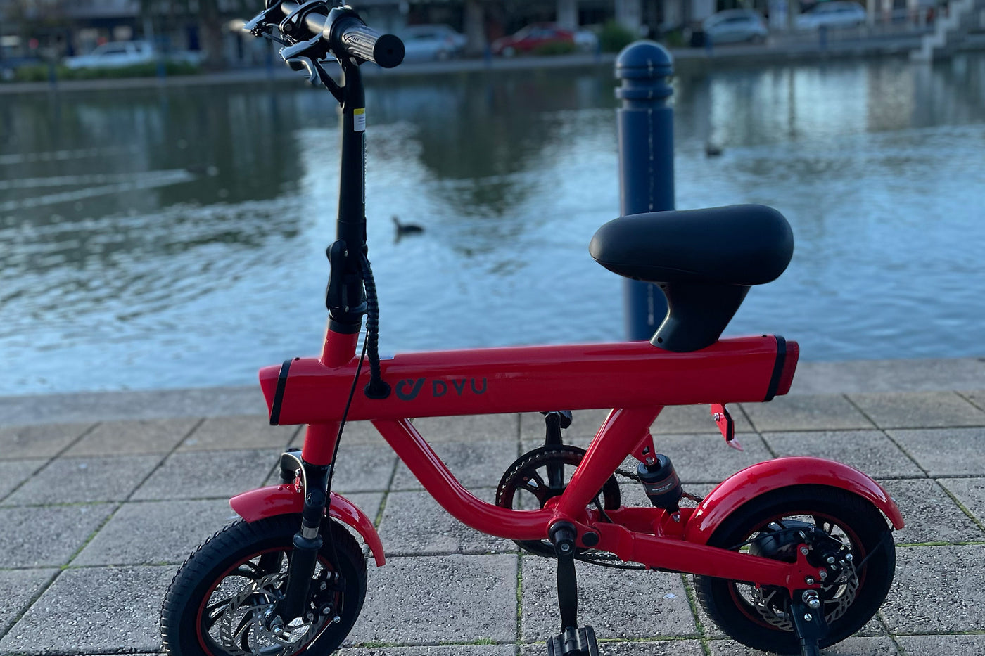 DYU V1 Smart electric bike red next to lake outdoors